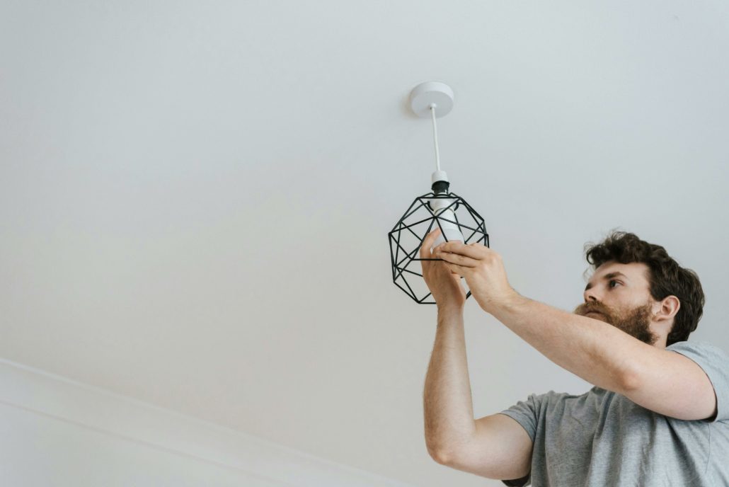Bearded man changing a light bulb