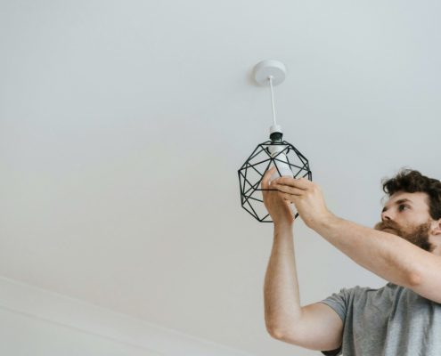 Bearded man changing a light bulb