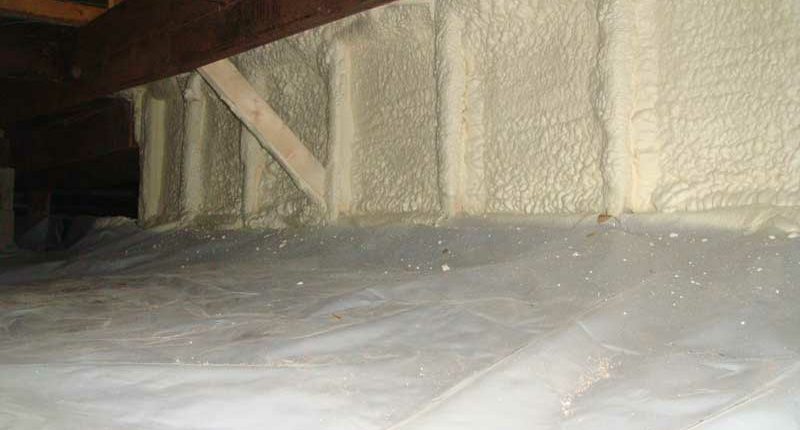 A crawlspace with insulation materials installed along the perimeter walls, including batt insulation, foam board panels, and spray foam, ensuring thermal efficiency and protection against freezing pipes.