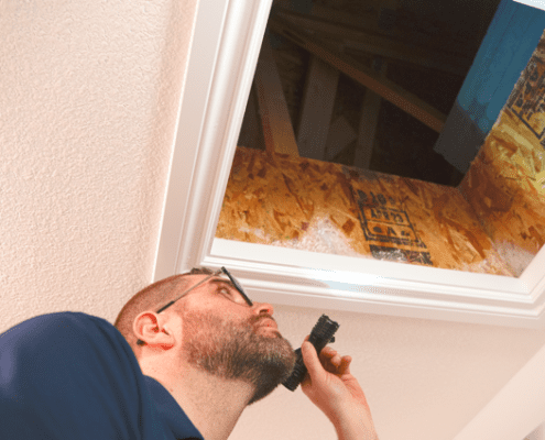 Home inspector inspecting attic space - Inspection Works