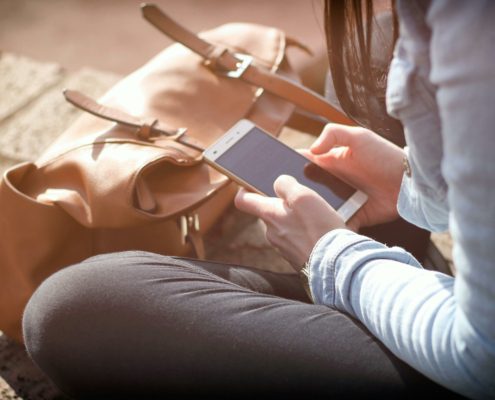 Person sitting down using smartphone