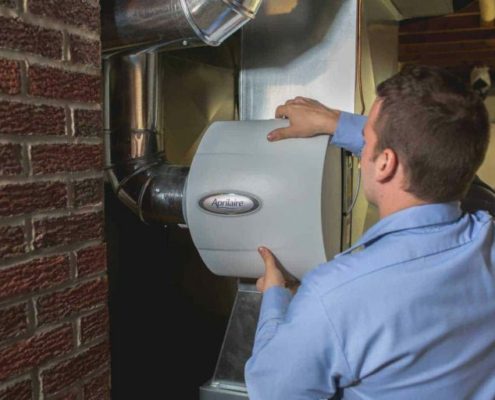 A technician servicing a central air humidifier.