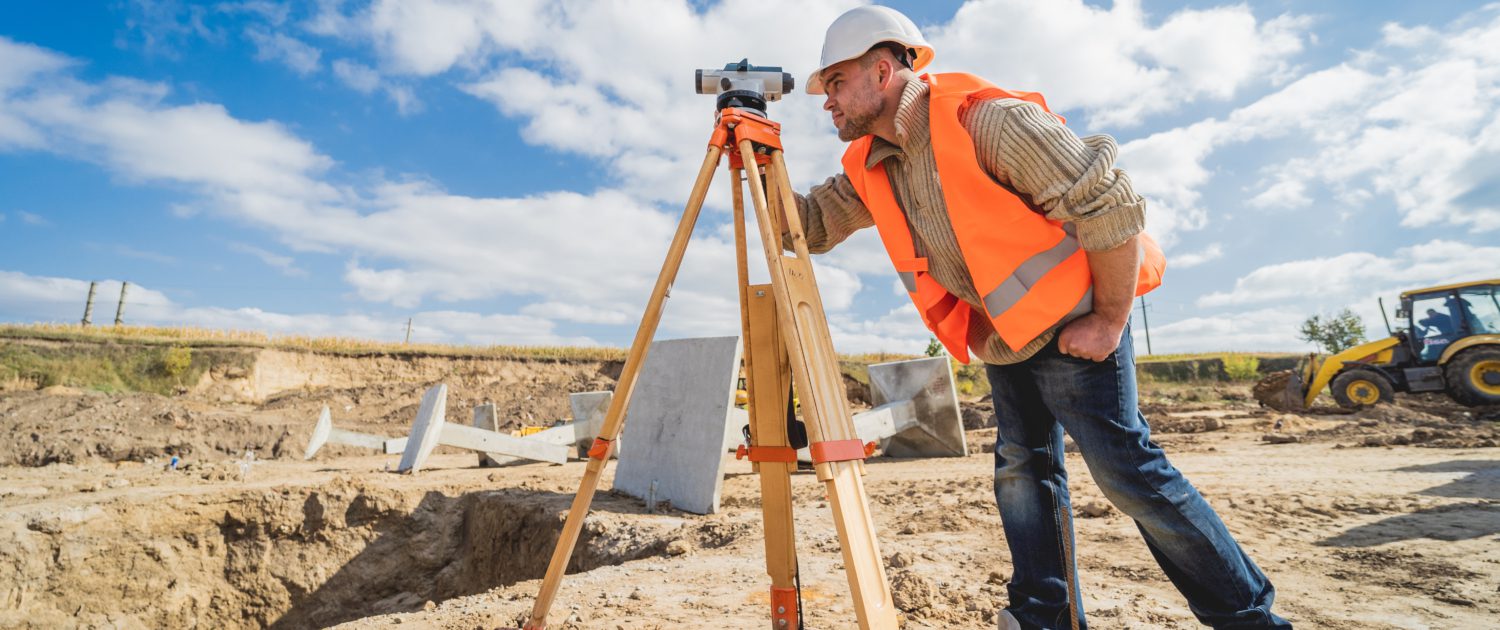 Surveyor installing a boundary marker in a new subdivision.
